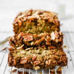 Across shot of vegan zucchini bread sliced on a cooling rack.