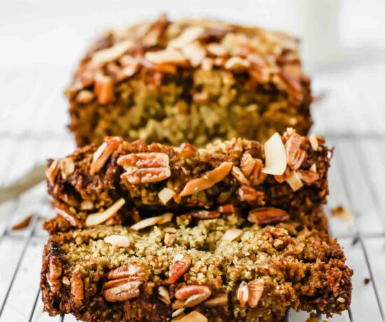 Across shot of vegan zucchini bread sliced on a cooling rack.