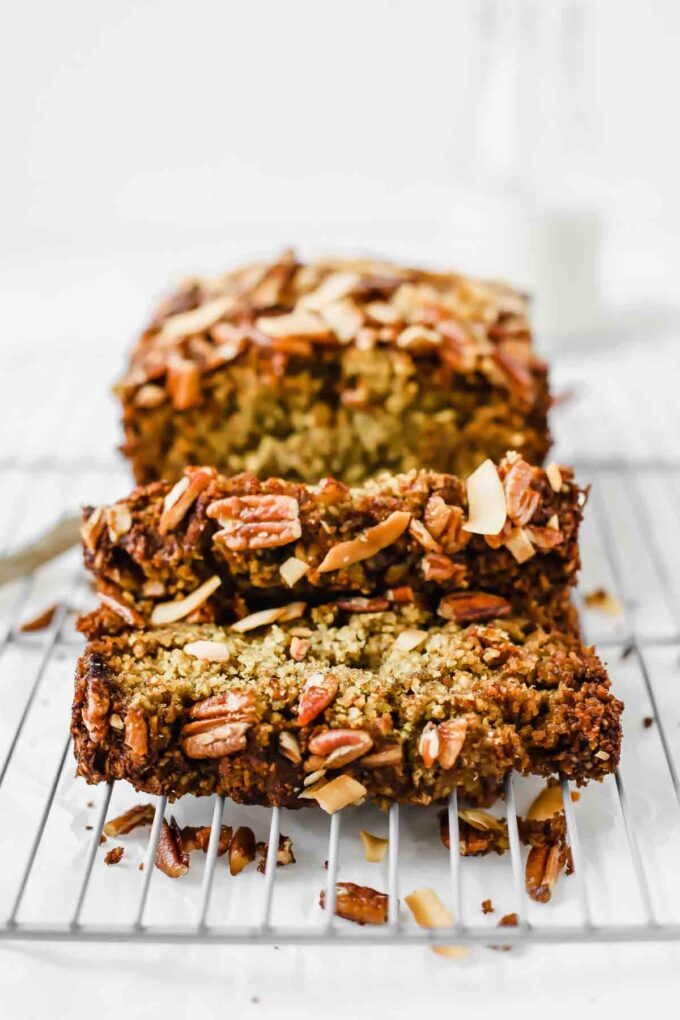 Across shot of vegan zucchini bread sliced on a cooling rack.
