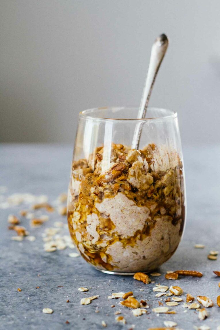 Maple Cinnamon Pecan Overnight Oats in a glass with a spoon.