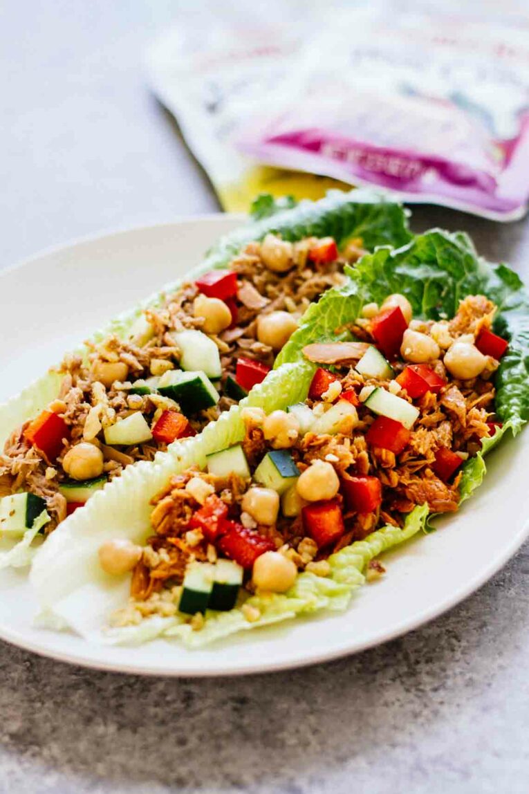 Side angle of On-The-Go Tuna Lettuce Wraps with Bumble Bee® Seasoned Tuna Pouches with Spoon on a white plate