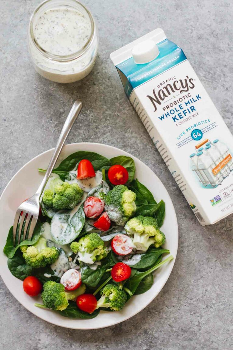 10-Minute Healthy Ranch Dressing in a mason jar next to a container of kefir next to a salad