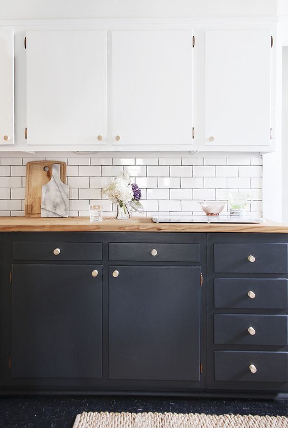Picture of kitchen cabinets. top cabinets are white bottom cabinets are black subway tile backsplash