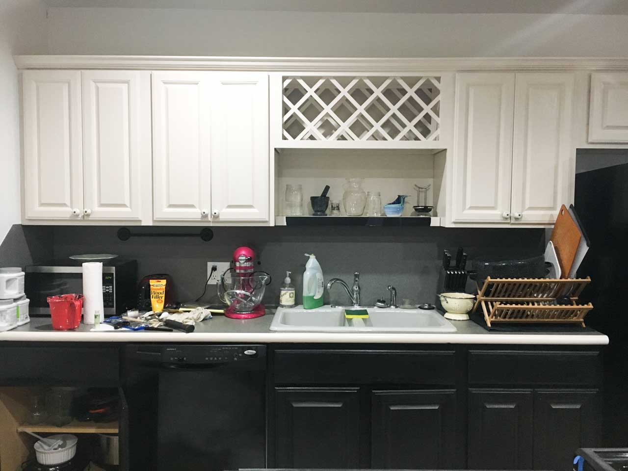 image of kitchen with white cabinets on top and dark cabinets on bottom