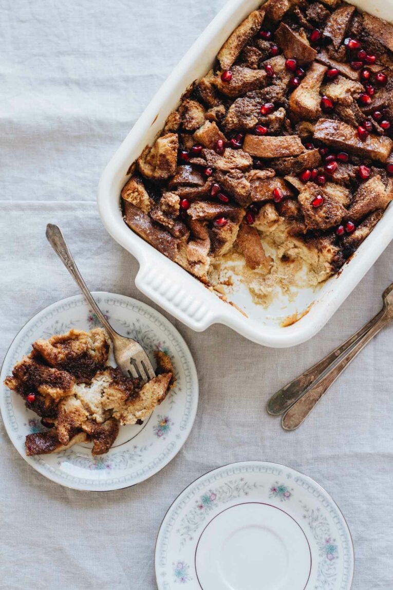 Easy Gingerbread French Toast Bake in a white baking dish being served on a plate with a fork