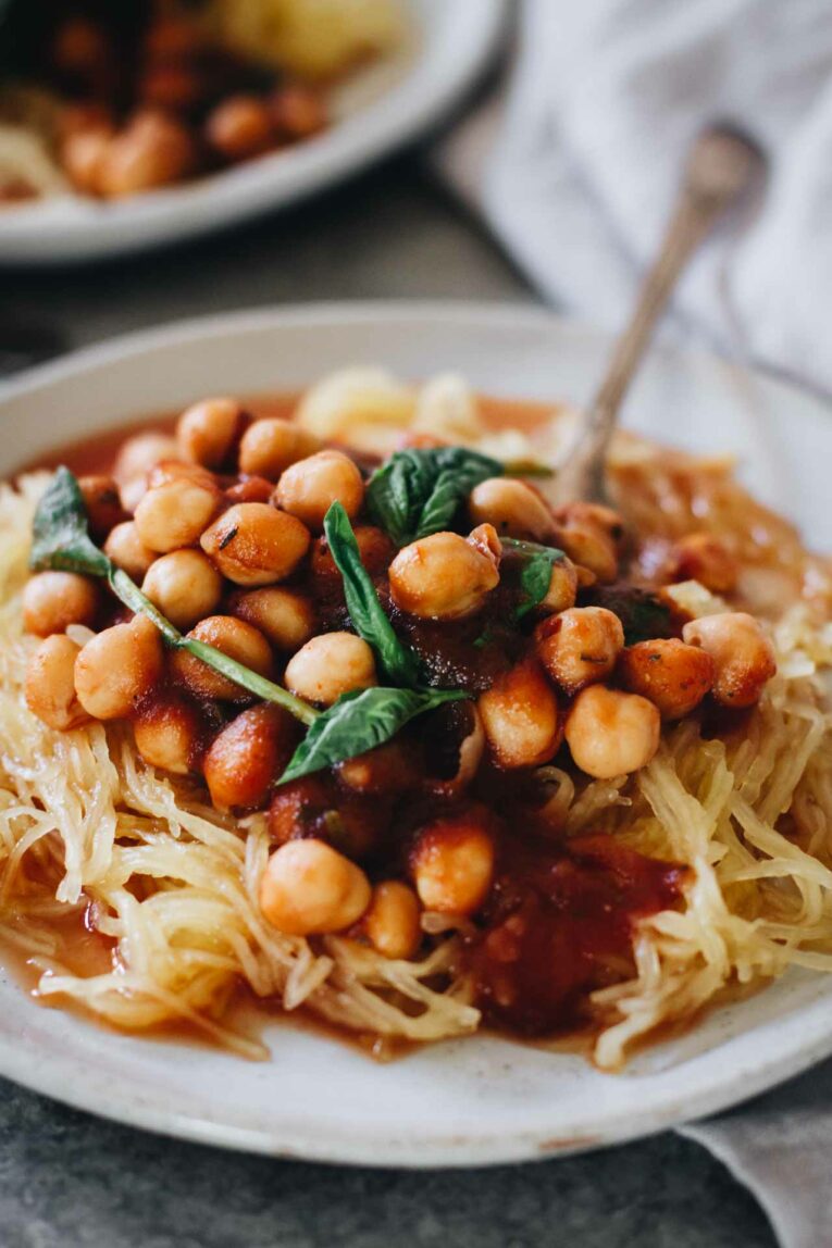 Close up of Garlic Chickpea Spaghetti Squash on a white plate with a fork