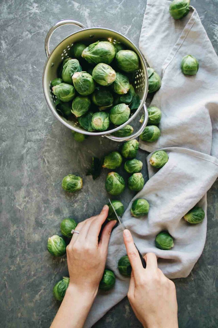 Brussels Sprouts on table being sliced.