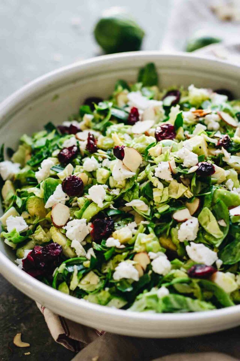 Shaved Brussels Sprout Salad w/ Cranberries in a grey bowl.
