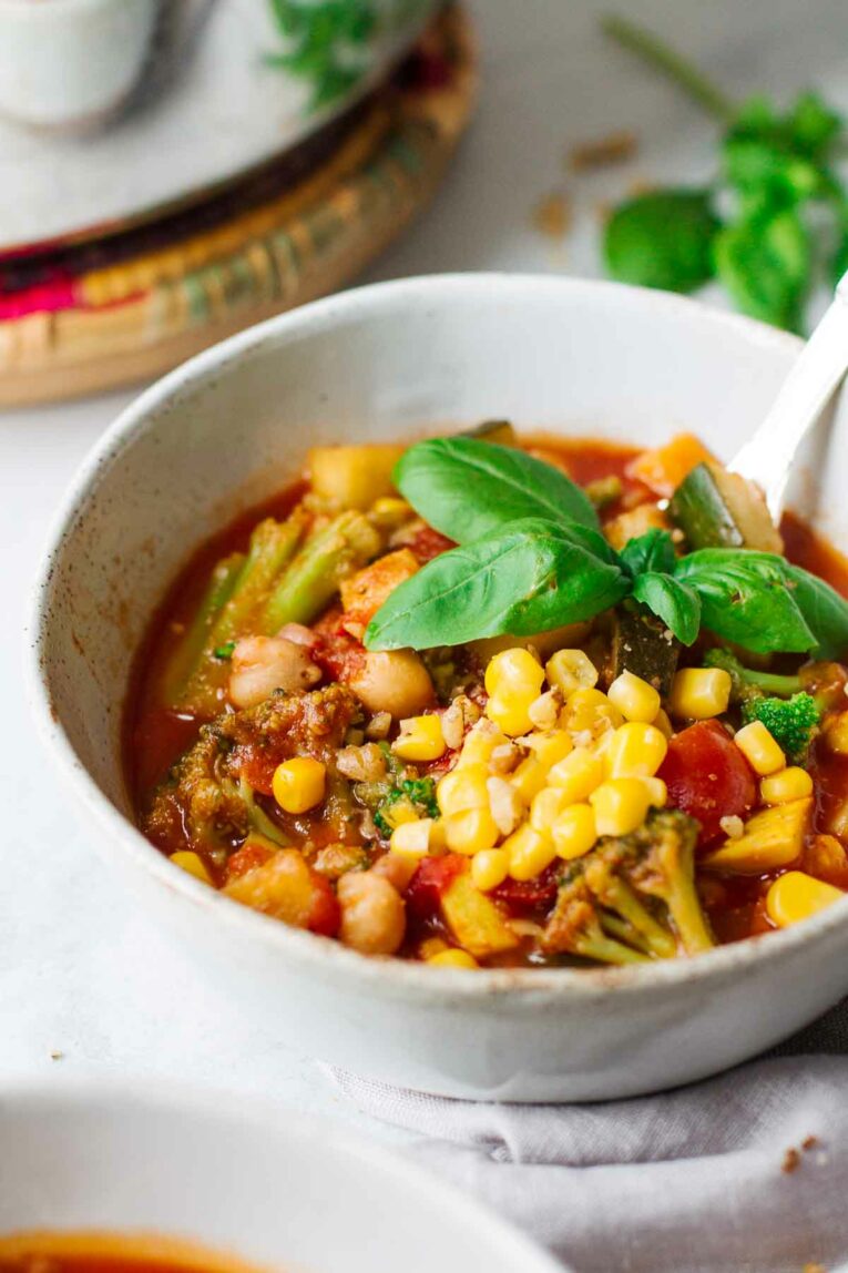 Close up shot of Easy Vegetarian Summer Chili in a white bowl with a spoon.