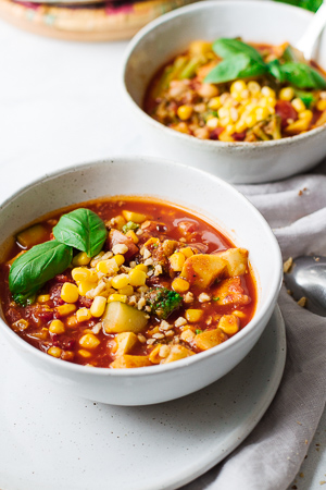 Easy Vegetarian Summer Chili in bowls on a white marble table.