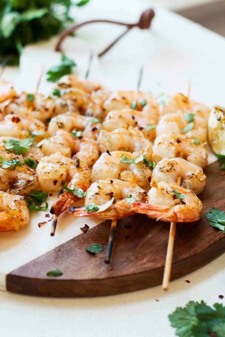 Close up shot of Spicy Grilled Shrimp on skewers on a cutting board. 