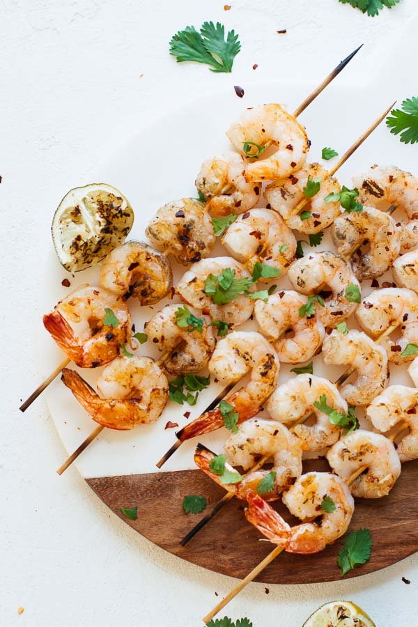 Overhead shot of Spicy Grilled Shrimp on a cutting board and white table