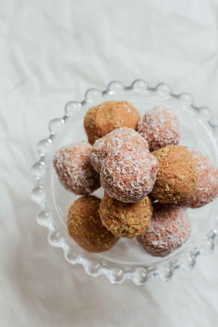 Strawberry Cheesecake No-Bake Energy Bites made with rolled oats, creamy cashew butter, vegan protein powder, coconut oil, agave, and freeze dried strawberries. So good! (Vegan, Gluten Free)