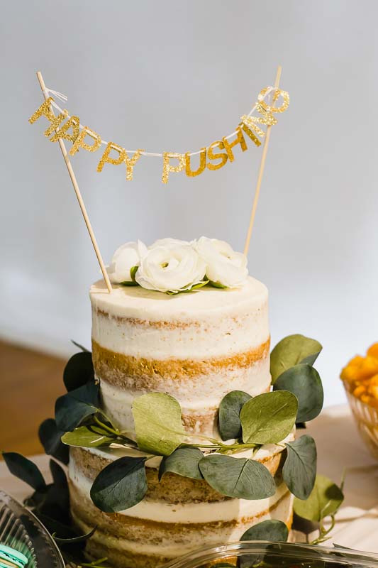 Happy pushing sign on a white stacked cake.