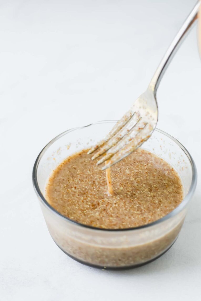 Egg dripping Easy Flax Egg Recipe into a glass bowl.