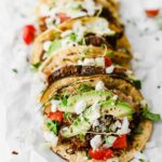 Easy Mexican Barbacoa Tacos by Jar Of Lemons! Corn tortillas topped with slow cooked chuck roast beef, avocado, tomatoes, onions, and feta cheese. So yummy!