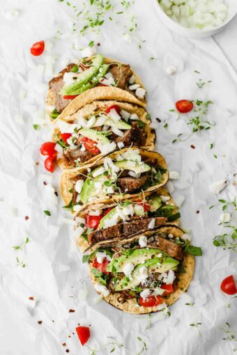 Easy Mexican Barbacoa Tacos by Jar Of Lemons! Corn tortillas topped with slow cooked chuck roast beef, avocado, tomatoes, onions, and feta cheese. So yummy!