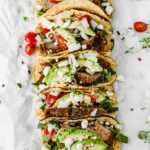 Easy Mexican Barbacoa Tacos by Jar Of Lemons! Corn tortillas topped with slow cooked chuck roast beef, avocado, tomatoes, onions, and feta cheese. So yummy!