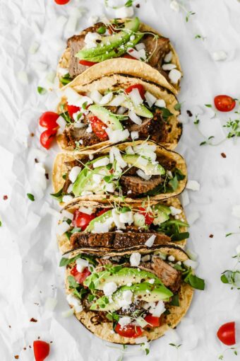 Easy Mexican Barbacoa Tacos by Jar Of Lemons! Corn tortillas topped with slow cooked chuck roast beef, avocado, tomatoes, onions, and feta cheese. So yummy!