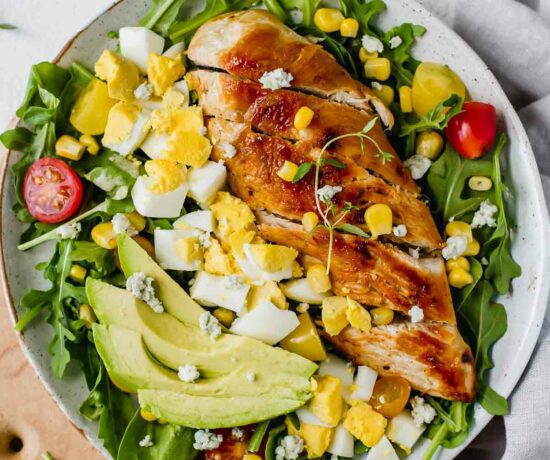 Healthy Chicken Cobb Salad Recipe loaded with spicy greens, creamy avocado, boiled eggs, fresh tomatoes, corn, delicious grilled chicken, and topped with a sprinkle of blue cheese crumbles. So yummy! (Gluten Free)