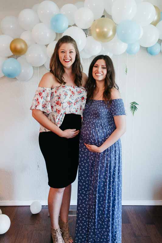 Two girls showing their baby bumps.