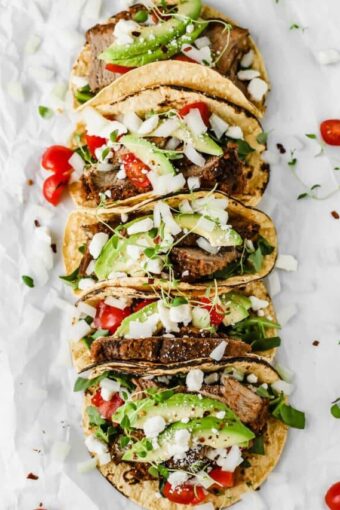 Easy Mexican Barbacoa Tacos by Jar Of Lemons! Corn tortillas topped with slow cooked chuck roast beef, avocado, tomatoes, onions, and feta cheese. So yummy!