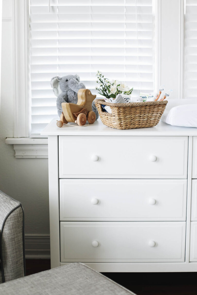 White dresser with baby items on top.