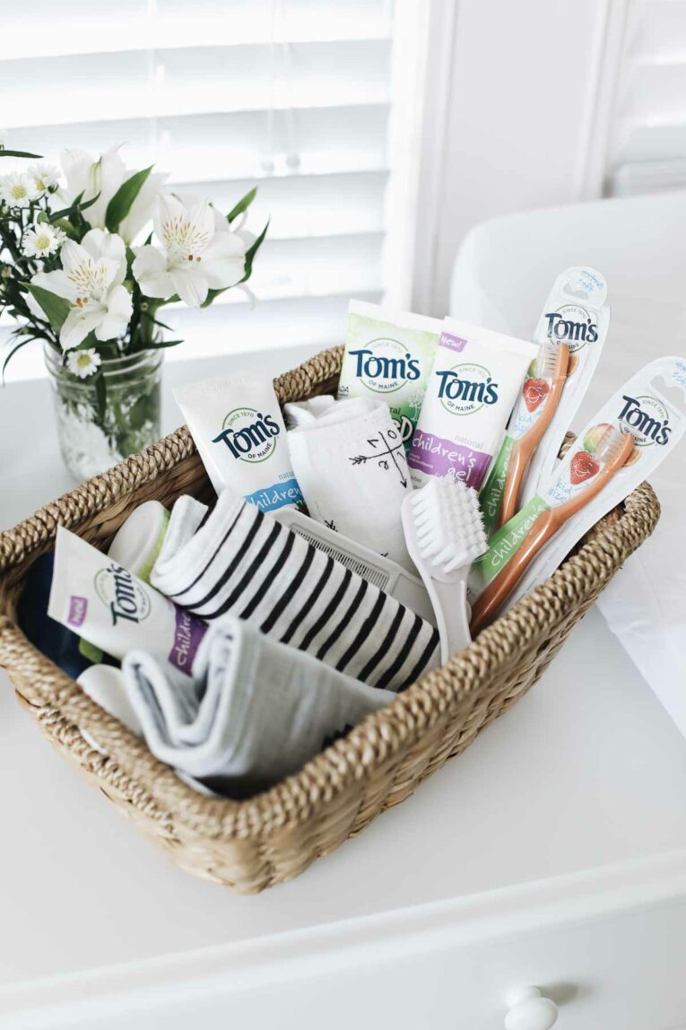 basket full of Tom's baby items next to small bouquet of flowers.