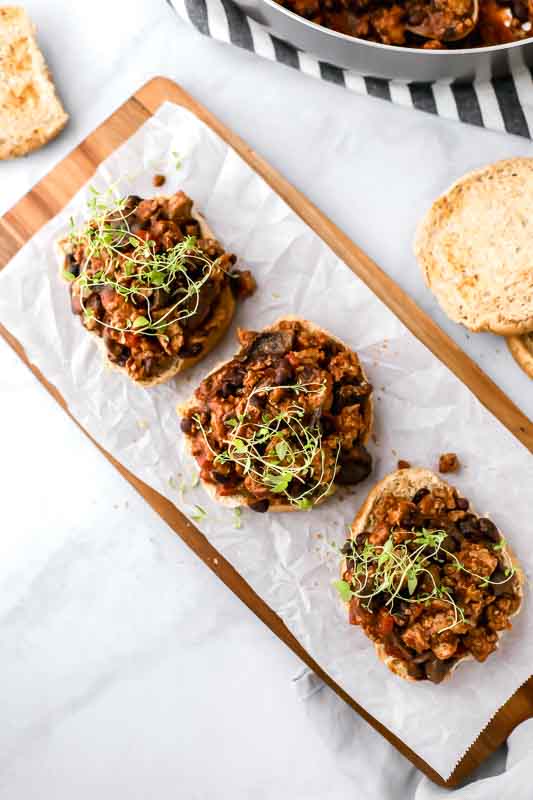 30-Minute Healthy Sloppy Joes being served on hamburger buns on a cutting board.