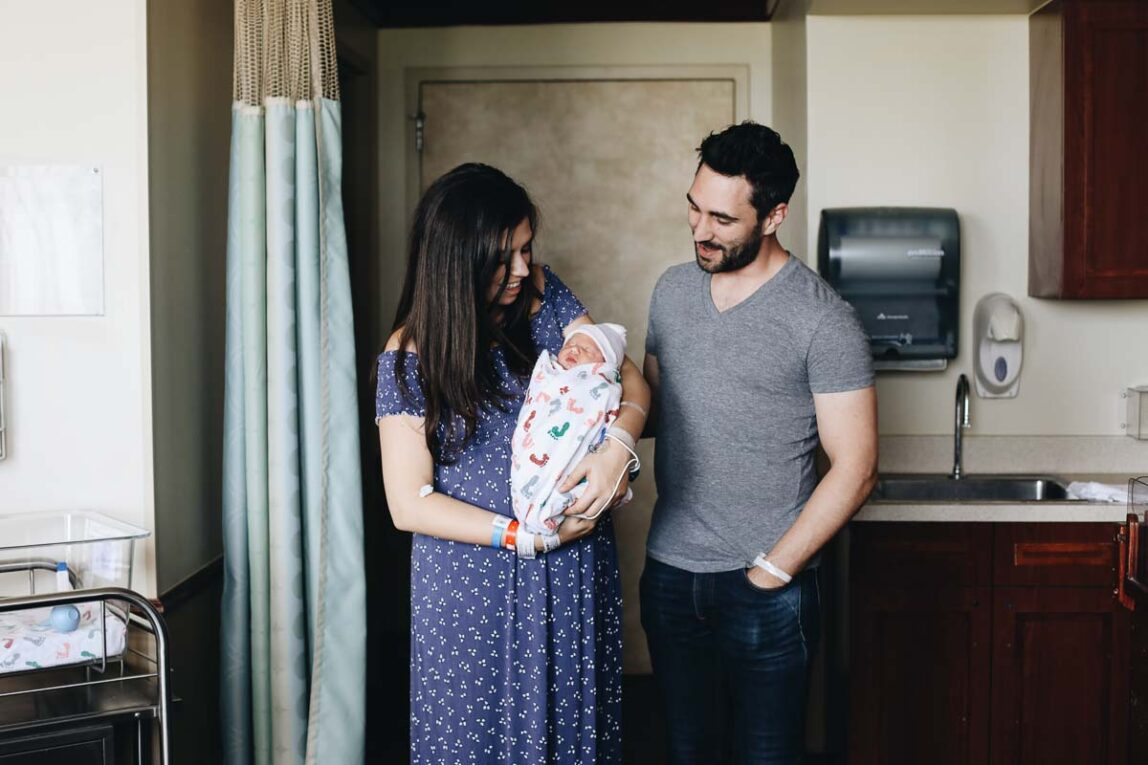 Couple holding newborn baby in the hospital.