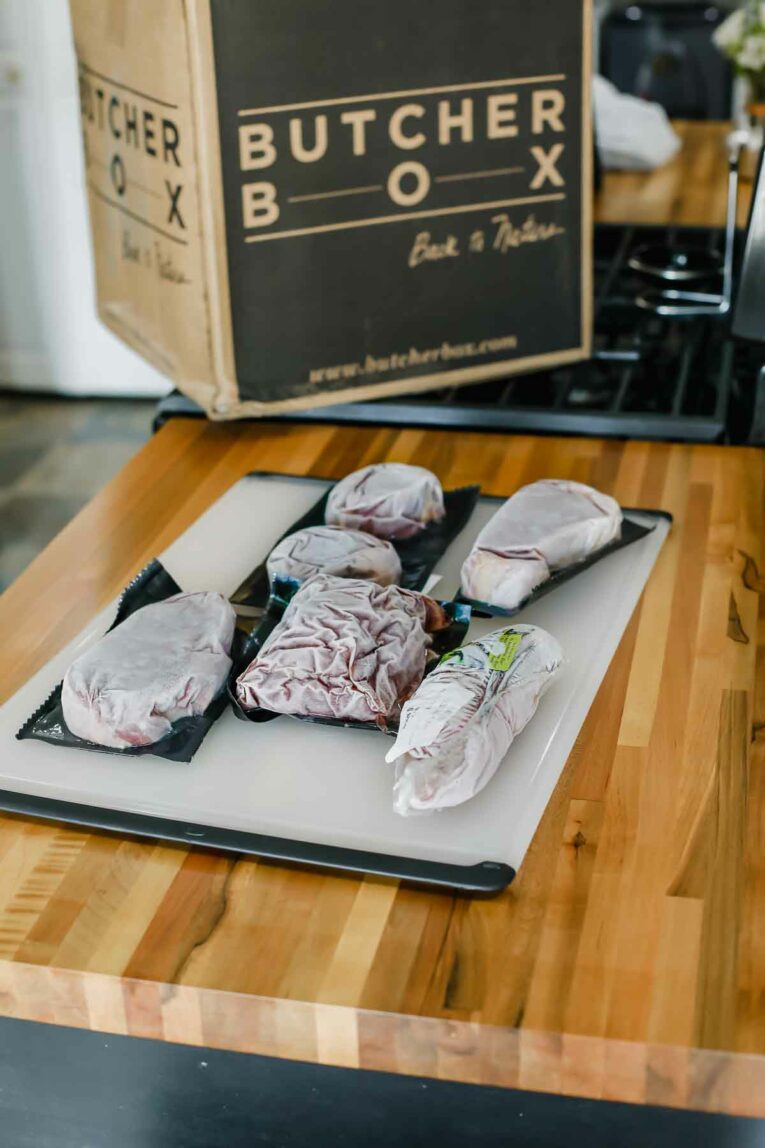 butcher box meat on a cutting board next to butcher box.
