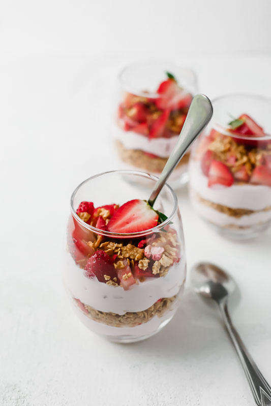 5-Minute Strawberry Cheesecake Breakfast Parfait in a glass with a spoon.