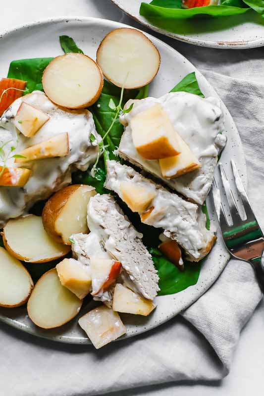 Slow Cooker Pork Chops with Potatoes and Apples on a White Plate