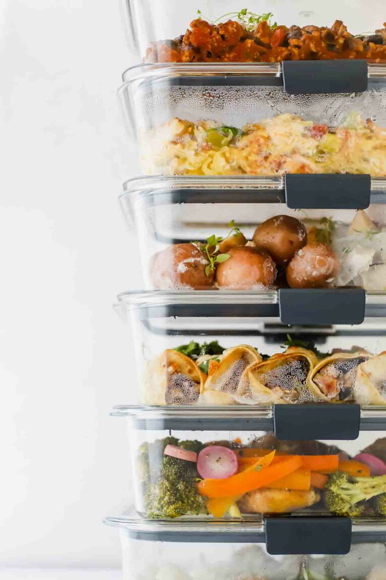6 Healthy Freezer Meals For New Moms (Or Anyone!) in freezer meal containers stacked on top of each other.
