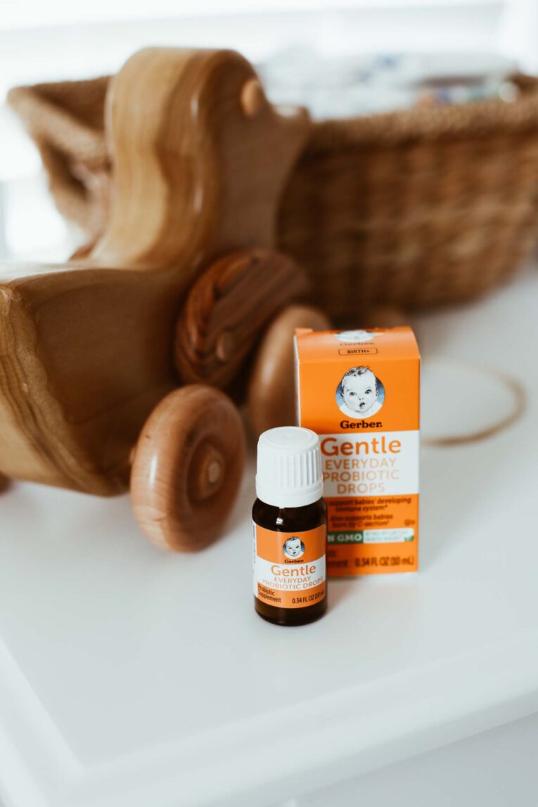 Gerber Probiotic drops next to baby toy on dresser.