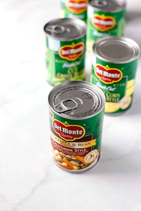 Del Monte cans of vegetables sitting on a countertop.