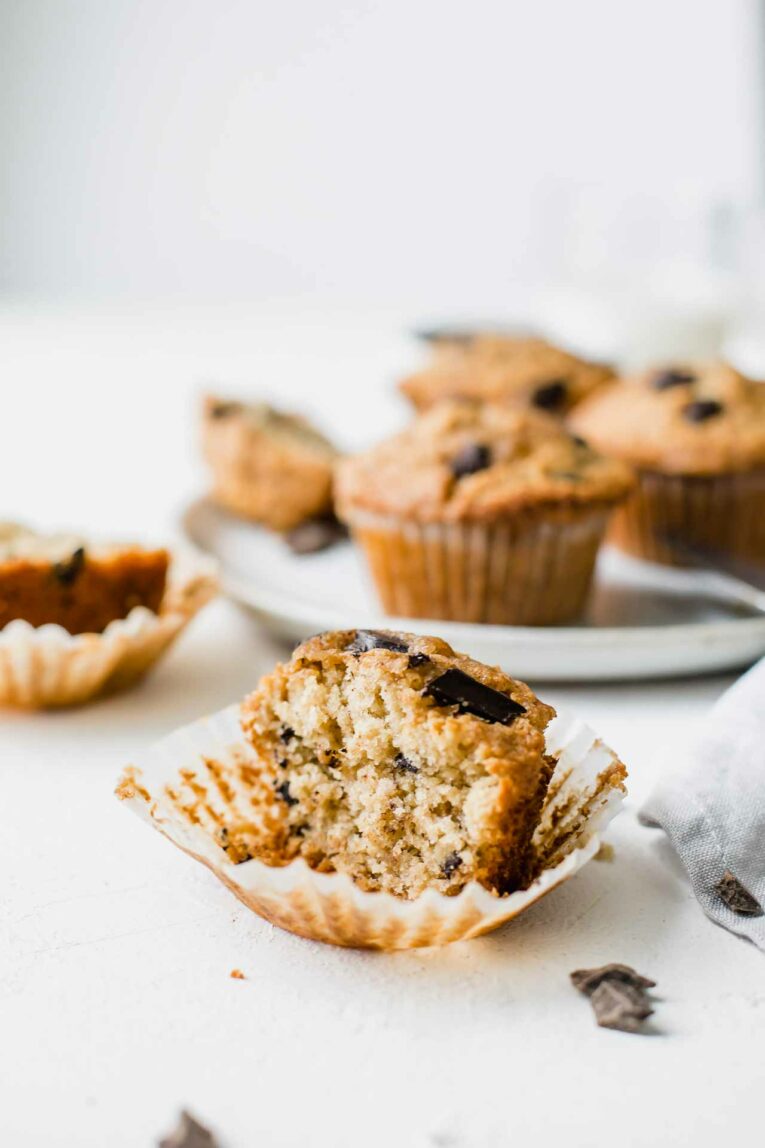 Half of an oatmeal muffin with chocolate chips on a table.