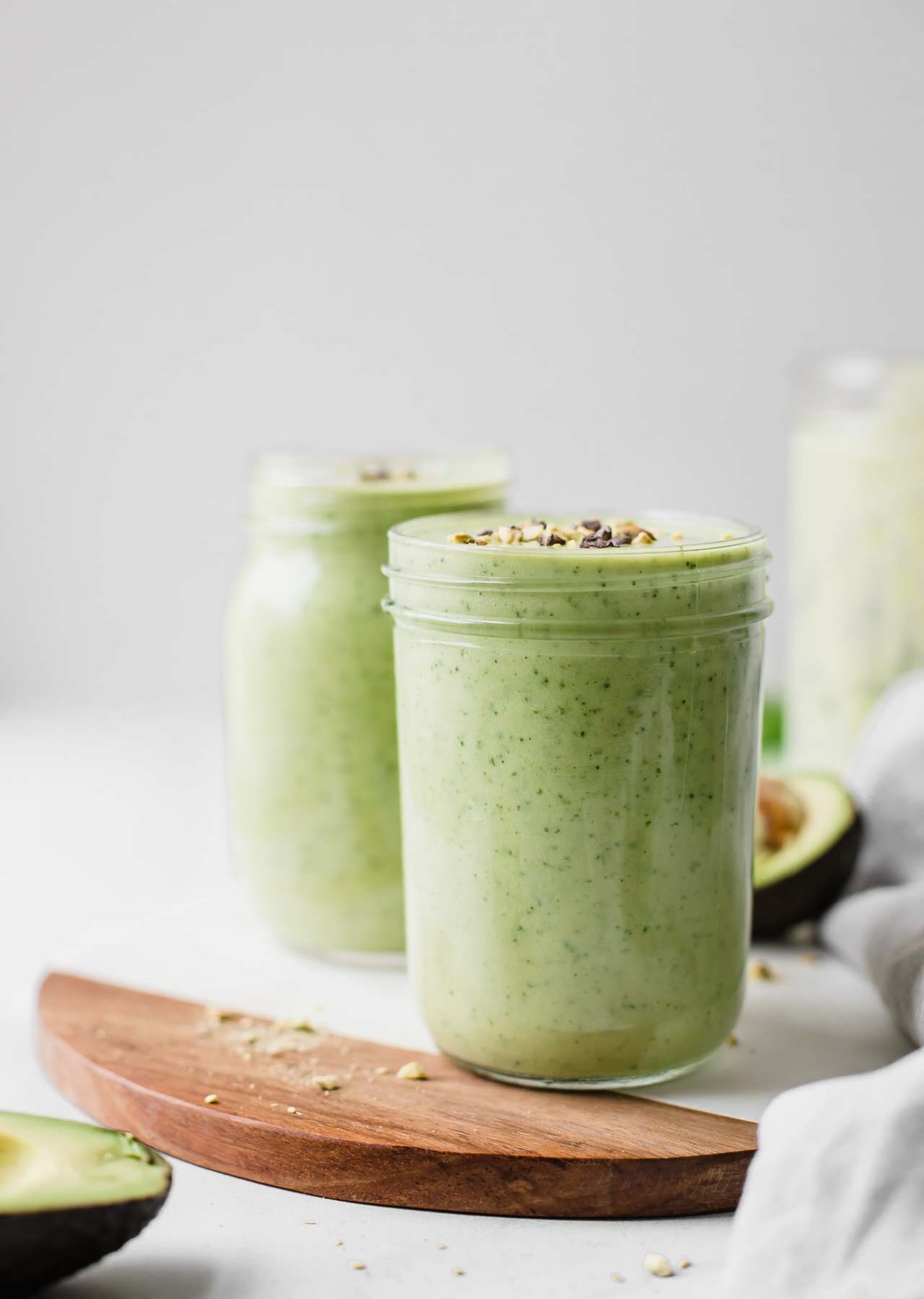 Two mason jars filled with avocado smoothie.