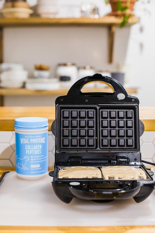 Waffle batter in a waffle maker next to Vital Proteins Collagen Peptides
