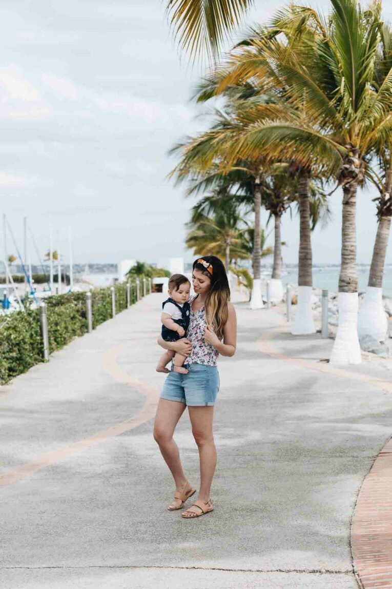 Going on a trip with your baby? You're going to want to have this printable checklist with you for traveling with a baby! Mom traveling with a baby to the beach.