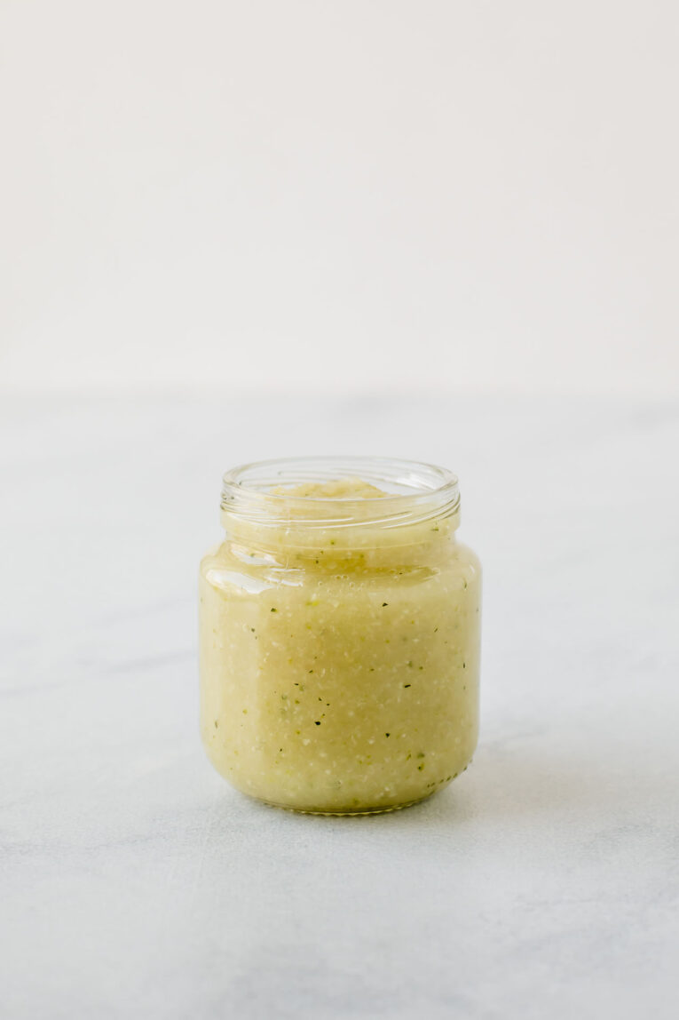 Zucchini baby food in a small jar.