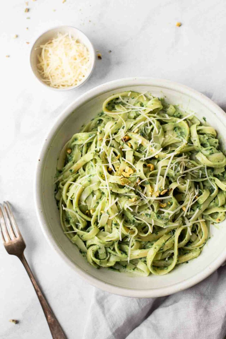 The BEST Avocado Pasta Sauce that can be made in 10-minutes or less! It's quick, easy, healthy, gluten-free, dairy-free, vegan, and delicious. Perfect for dinner tonight! Avocado pasta sauce over fettuccine and topped with cheese.