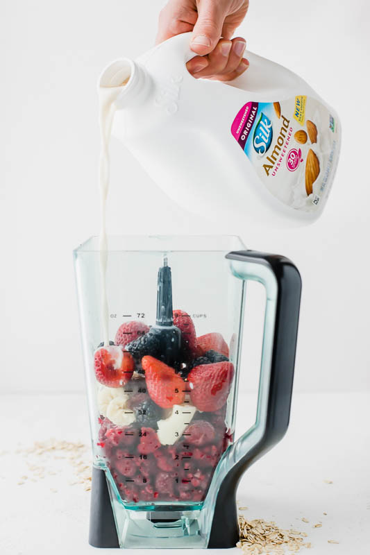 Silk Almondmilk being poured into a blender for a smoothie.