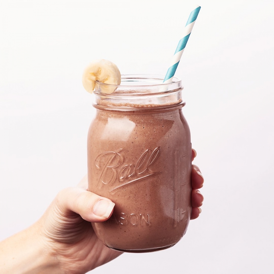 Want to know what the best Arbonne products are and what's so great about them? Today I'm sharing an honest review and amazing discount. If you're looking to make the switch to healthier, pure, botanical-based products and nutrition, then this post is for you! hand holding Arbonne Chocolate Shake in a mason jar with a striped straw.
