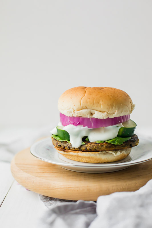 Veggie burger served on a plate on a cutting board.