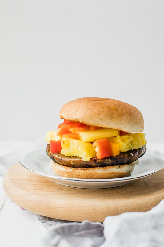 Veggie Burger served on a plate sitting on a cutting board.