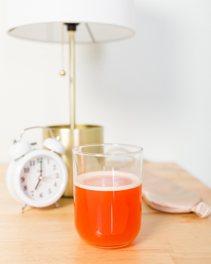 Want to know what the best Arbonne products are and what's so great about them? Today I'm sharing an honest review and amazing discount. If you're looking to make the switch to healthier, pure, botanical-based products and nutrition, then this post is for you! Arbonne Energy Fizz in a glass on a nightstand.