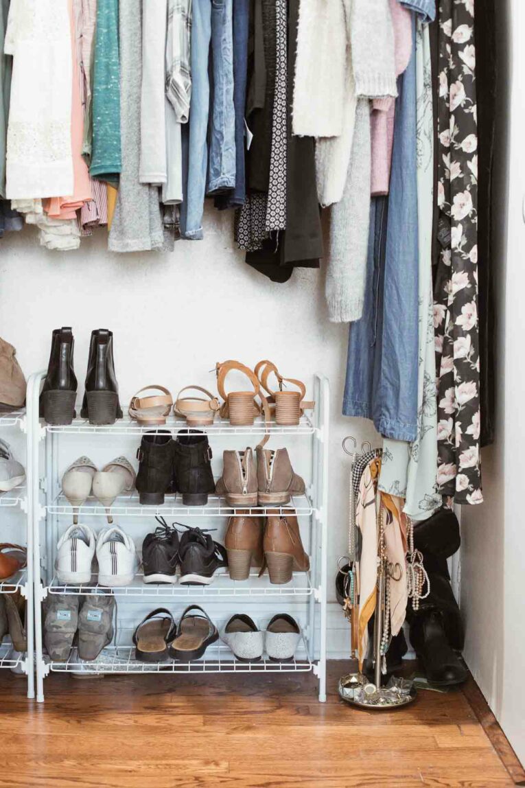 Organized closet with hanging clothes and a shoe rack underneath.