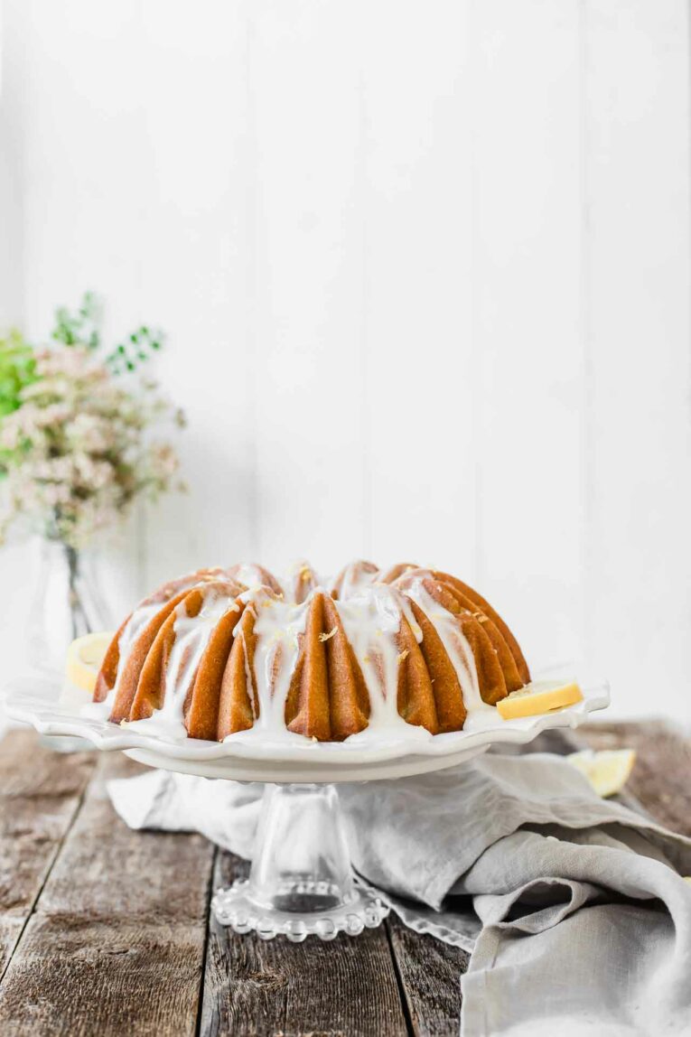 Looking for an easy dessert that will impress your guests at your next summer gathering? This Southern Sweet Tea Lemon Cake is light, fluffy, sweet, and tastes like everything summer! Beautiful sweet tea lemon bundt cake on a stand