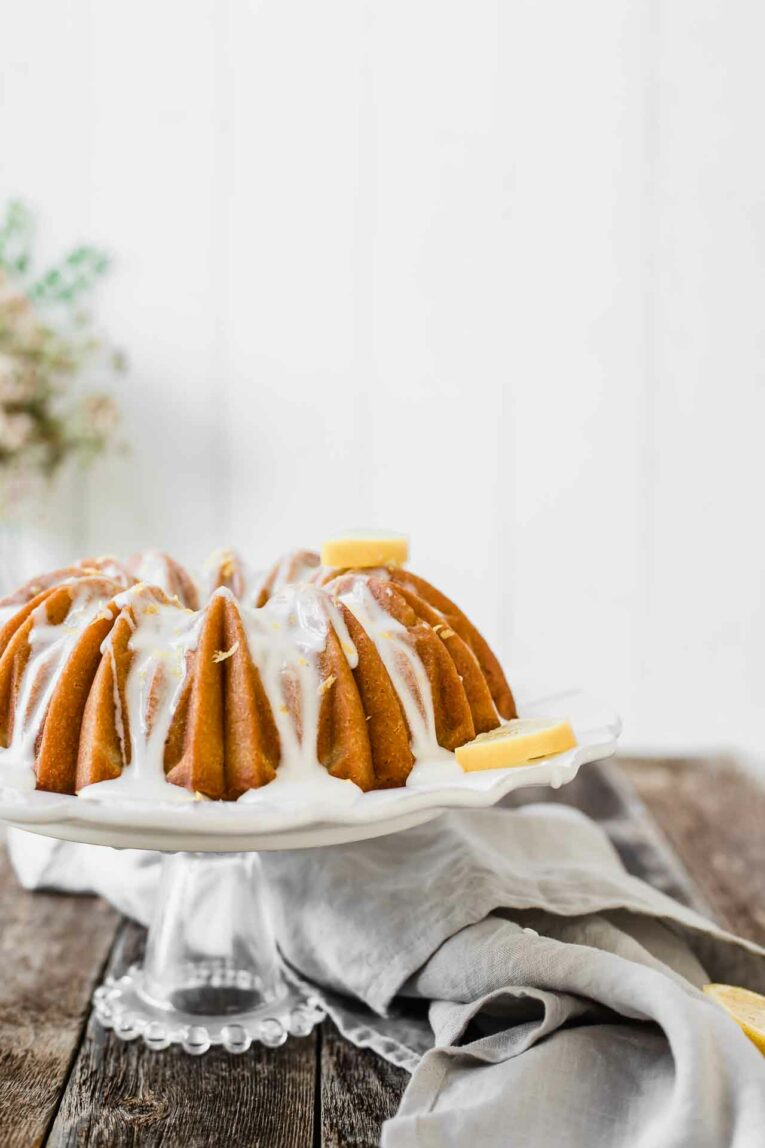 Looking for an easy dessert that will impress your guests at your next summer gathering? This Southern Sweet Tea Lemon Cake is light, fluffy, sweet, and tastes like everything summer! Sweet tea lemon cake on a stand.